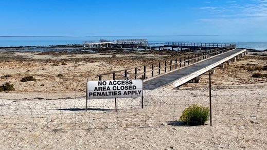 A photo of the stromatolites site at Hamelin Pool with a sign saying no access and a fence around it