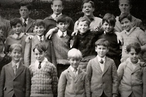 A black and white class photo of young boys in suits.