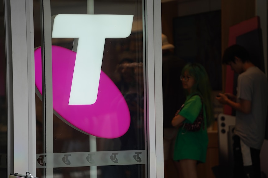 The Telstra logo on a glass shopfront.