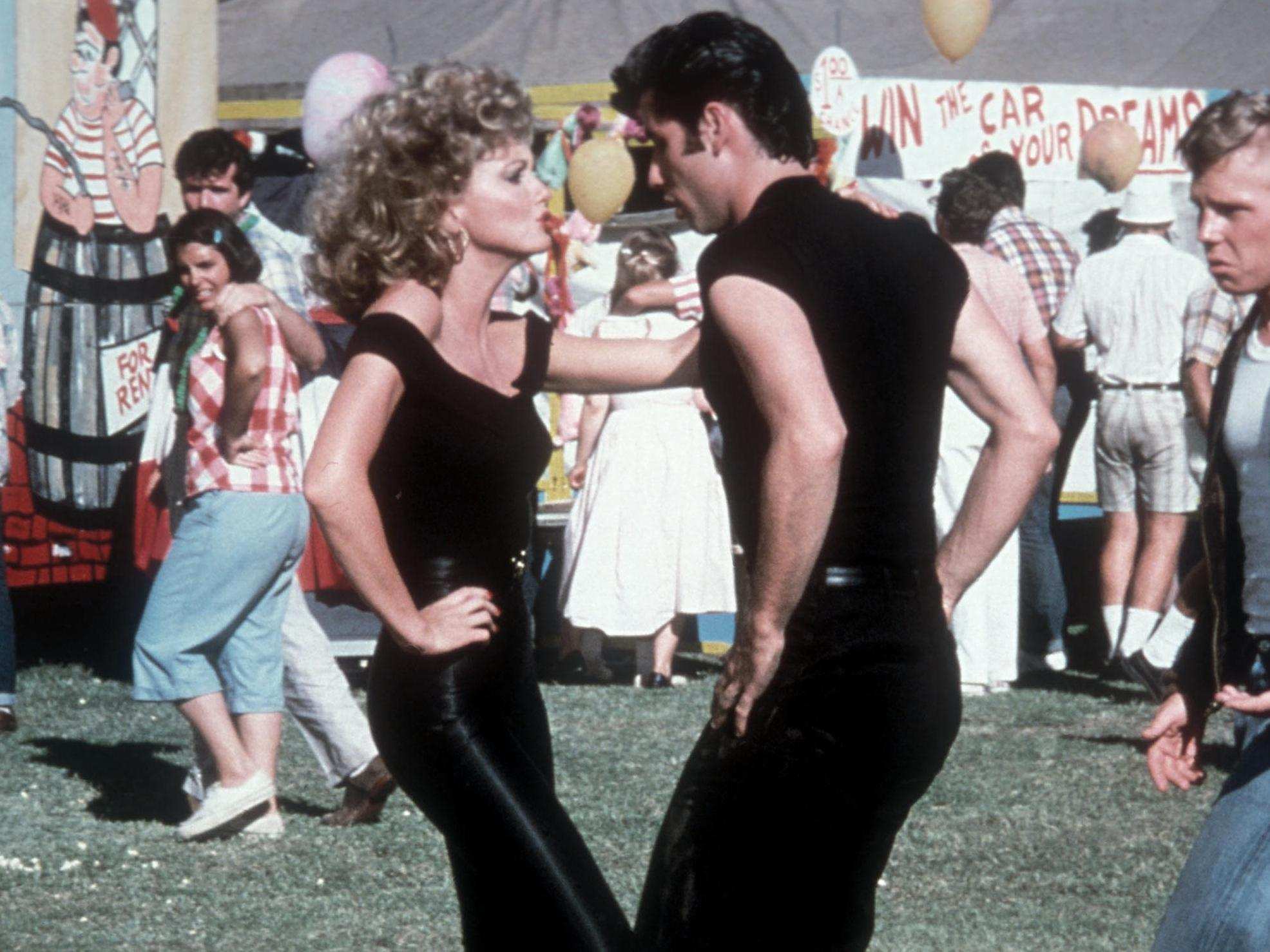 Olivia Newton-John and John Travolta dancing in a scene from Grease.  Both are wearing black.