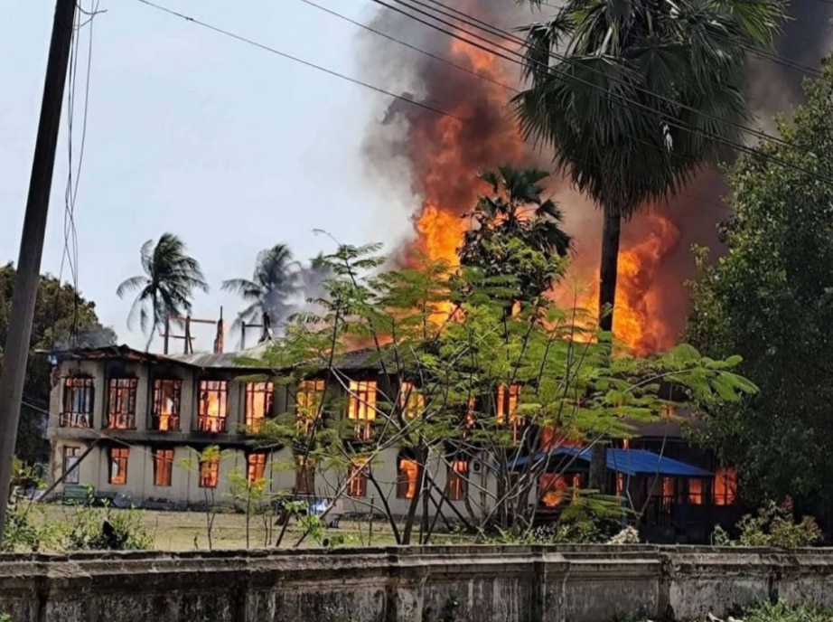 building on fire,  orange flames billowing.