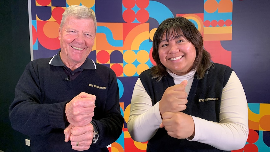 Man and woman smile for photo with fists stacked on top of each other