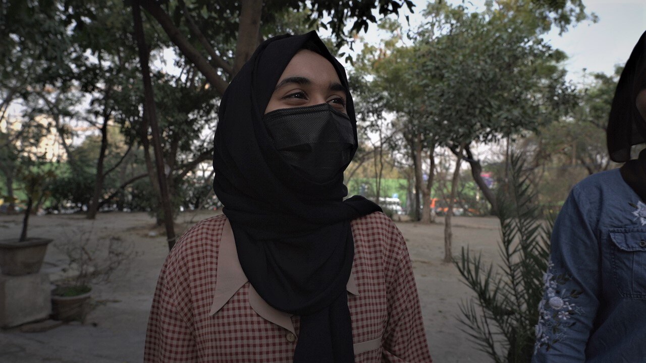 Muslim student wearing a hijab and black face mask.