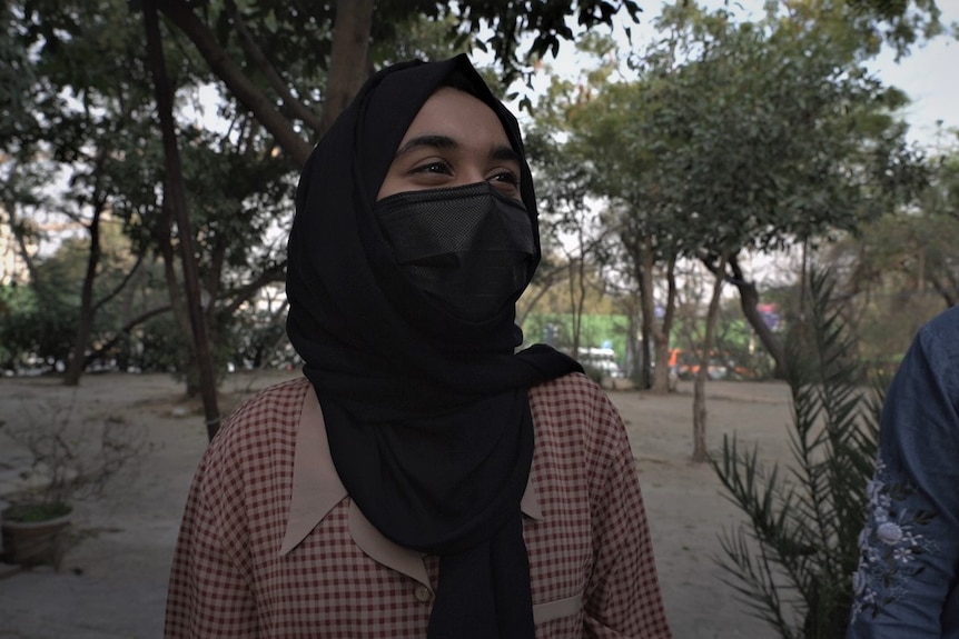 Muslim student wearing a hijab and black face mask.