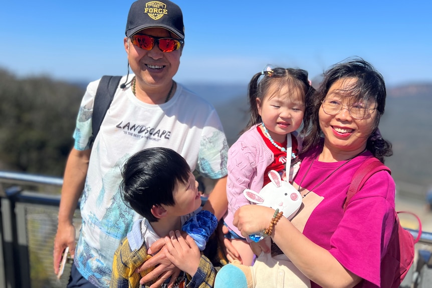 A Chinese family posing to camera, smiling.