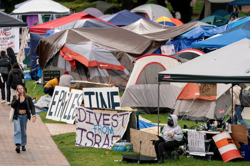 A large group of tents on a lawn, with signs that say things like 'Divest from Israel'.