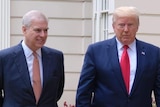 Prince Andrew and President Donald Trump walk together along a path outside St James Palace dressed in suits and ties