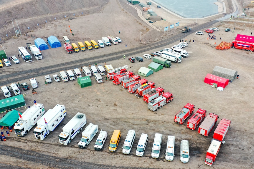 Aerial view of dozens of rescue vehicles parks at the site of an open pit coal mine.