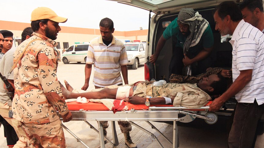An anti-Gaddafi fighter injured amid heavy shelling on a roundabout in Sirte receives medical treatment at a field hospital