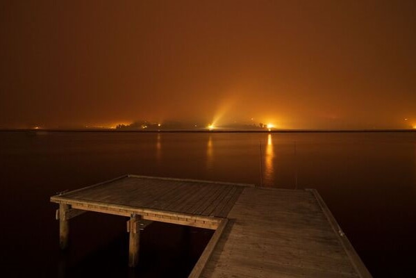 Smoky fire glow from Glaziers Bay looking to Castle Forbes Bay