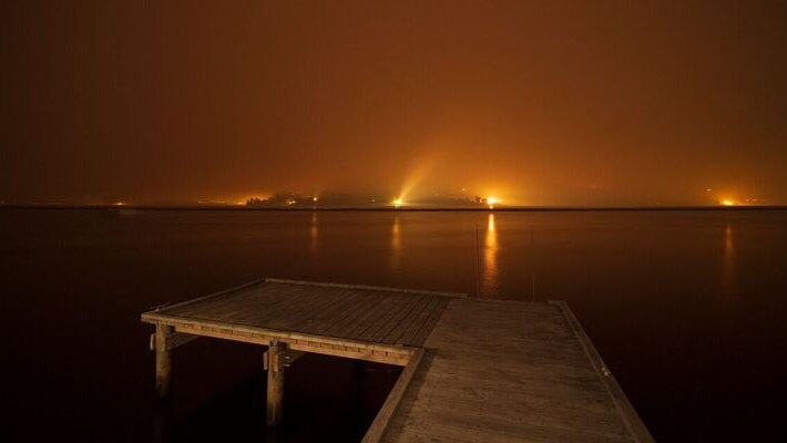 Smoky fire glow from Glaziers Bay looking to Castle Forbes Bay
