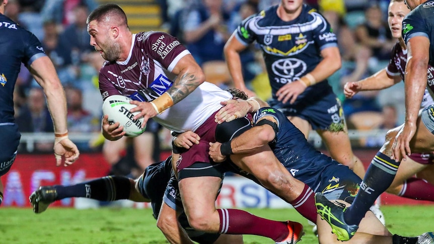 Curtis Sironen has two Cowboys players tackling him by the waste as he tries to force his body towards the tryline.