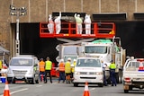 Workers clear the way to remove truck out of the Acton tunnel