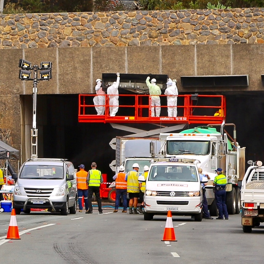 Workers clear the way to remove truck out of the Acton tunnel