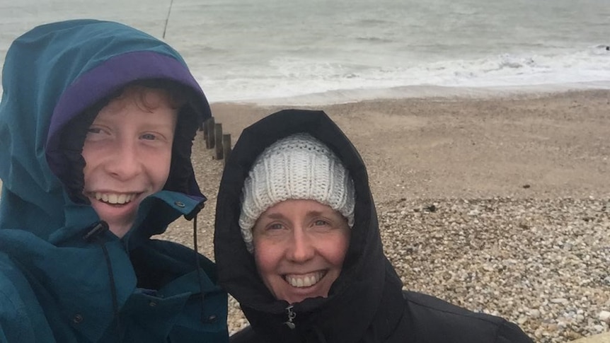 A photo of Jennifer( right) and Dan (left) at the beach on a cold day.