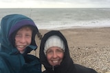 A photo of Jennifer( right) and Dan (left) at the beach on a cold day.