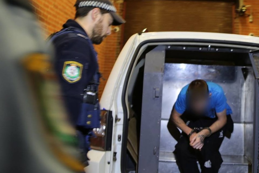 Man exits police van after being arrested over alleged Hazelbrook gang rape.