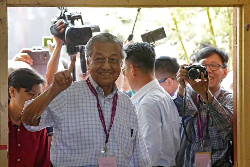 Former Malaysian strongman Mahathir Mohamad shows his finger after voting.