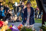 A girl lays flowers at a Bali bombings memorial service in Kings Park.