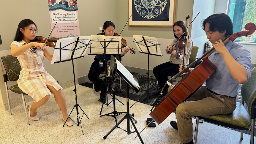 A string quartet perform on a hospital ward