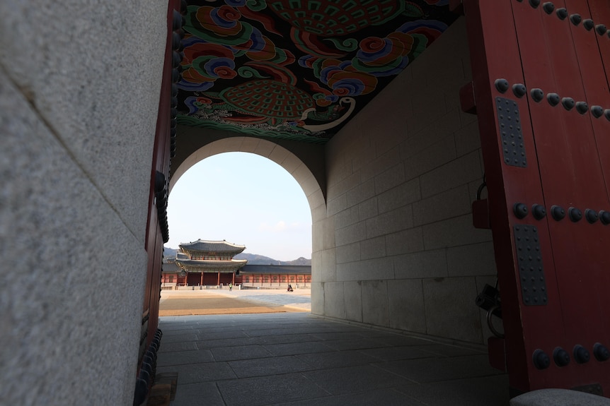 A tunnel looks through to a traditional South Korean structure