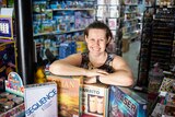 Board game store owner Cathy Bimrose poses in her shop with games for a story about fun board and card games to play.
