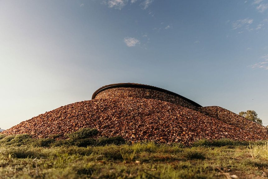 A round stone building structure on a hill made of stone