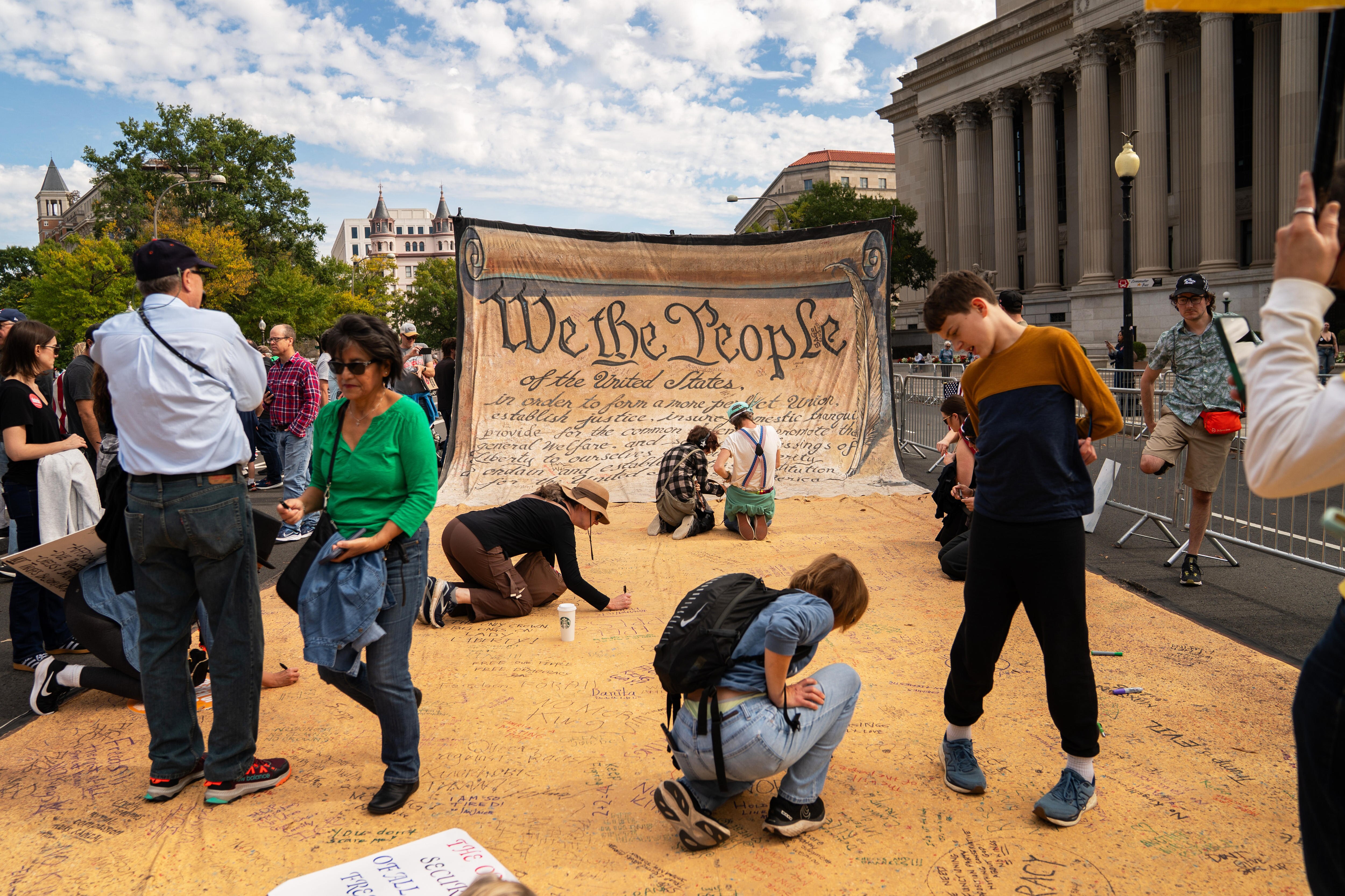 A giant 'We The People' US Constitution banner, being signed by protesters