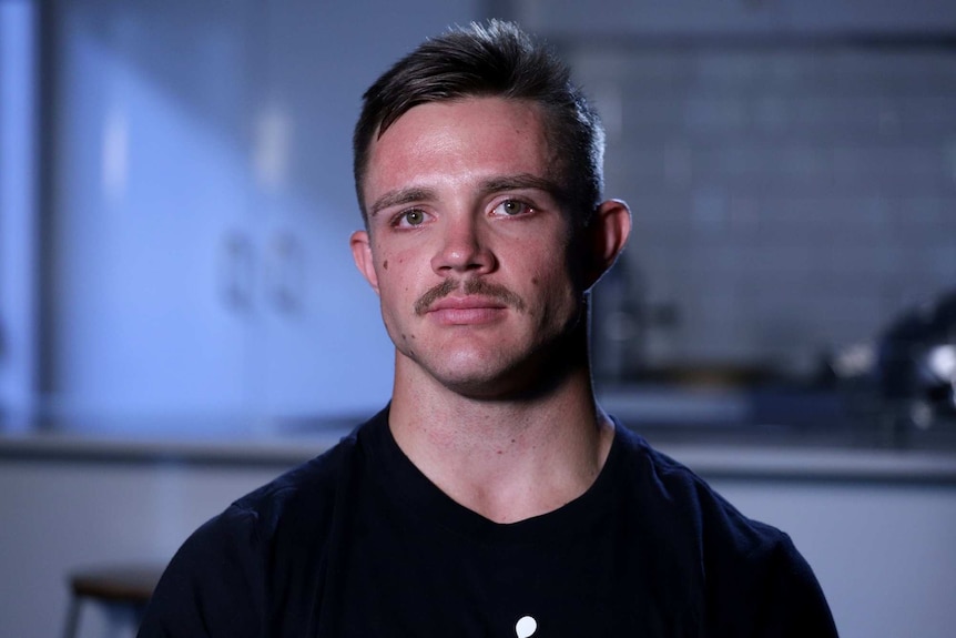 Head shot of Braeden Cester, wearing a black t-shirt, with short cropped hair and a moustache