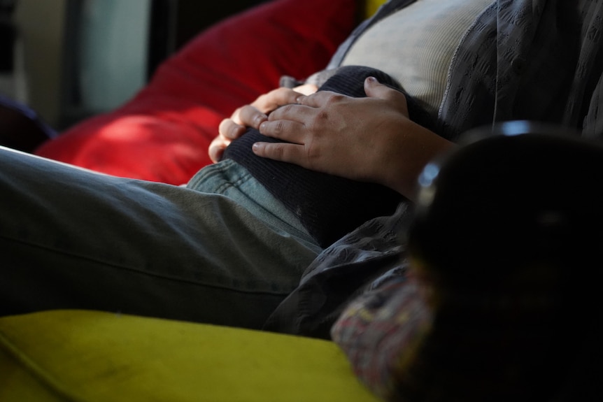 A close up of a heat pack being held against somebody's body.