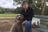 Ruth Quick sitting on a park bench with her dog, Sergio, and a packet of Applaws dog food