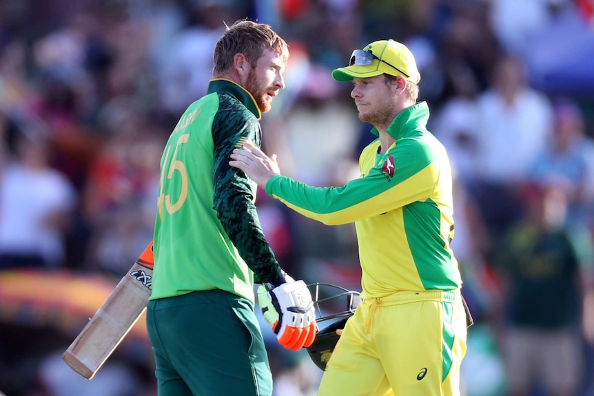 An Australian cricketer pats the shoulder of a South African batsman after their ODI.