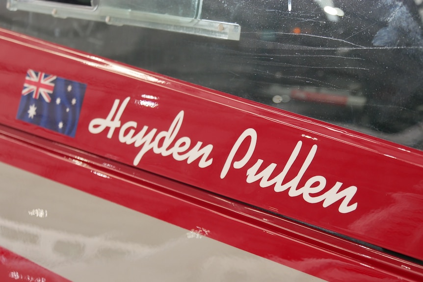 The name "Hayden Pullen" stencilled on the side of a brightly coloured aeroplane.