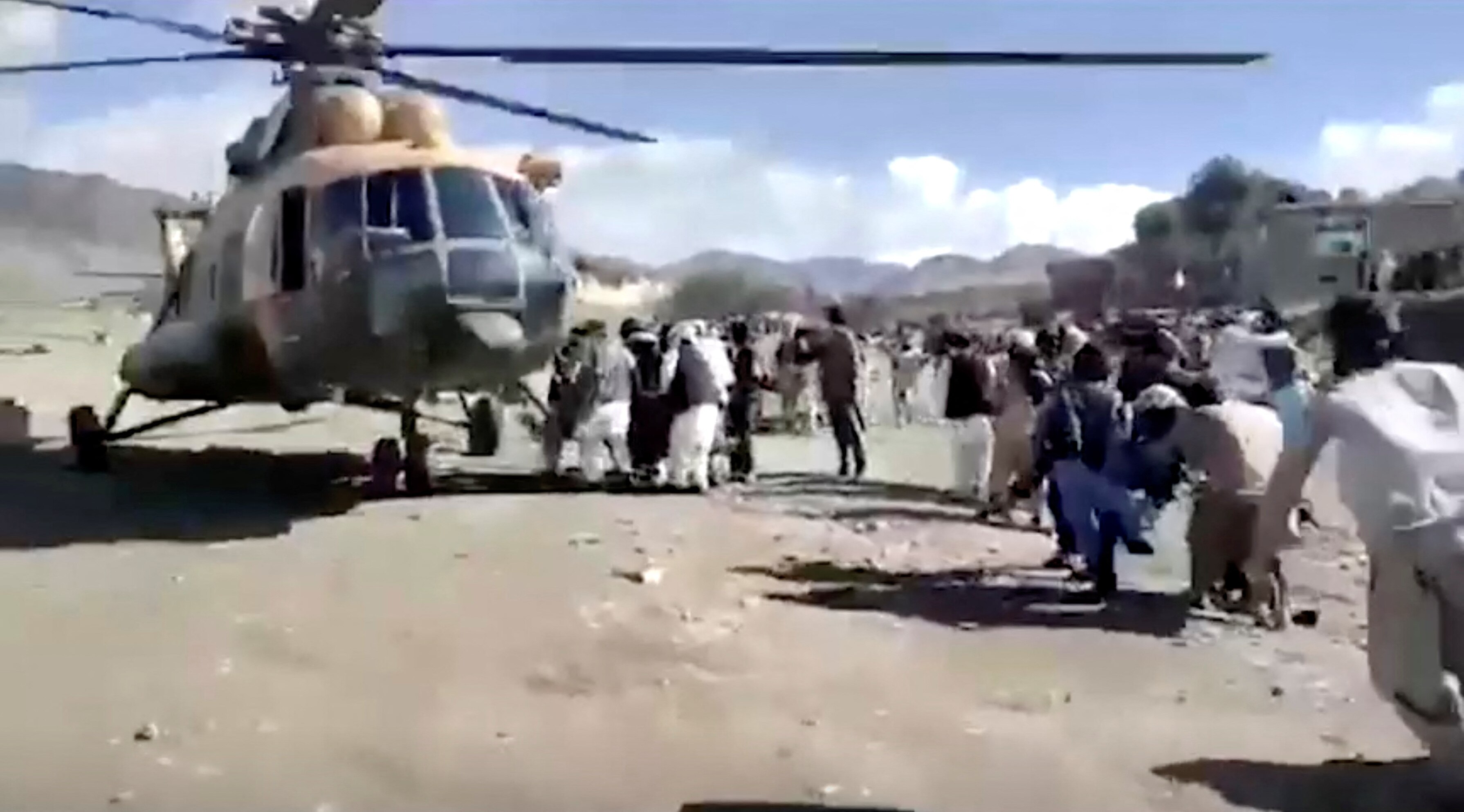 People carry the injured to a helicopter