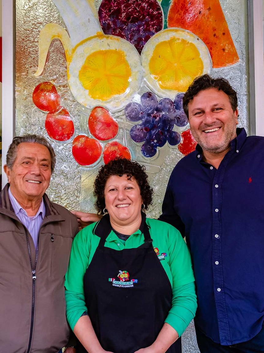 Two Australian-Italian men and a woman standing in front of a gelato shop.
