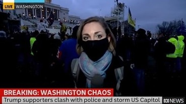 Still from news coverage of Diss reporting from in front of crowd outside Capitol.