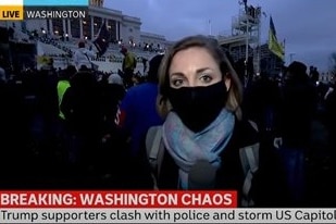 Still from news coverage of Diss reporting from in front of crowd outside Capitol.