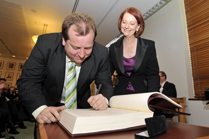 Julia Gillard watches as the new member for McEwen, Rob Mitchell, signs the ALP caucus book