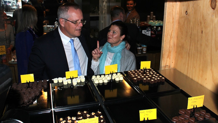 Prime Minister Scott Morrison looks at chocolates in a display cabinet with his wife Jenny.