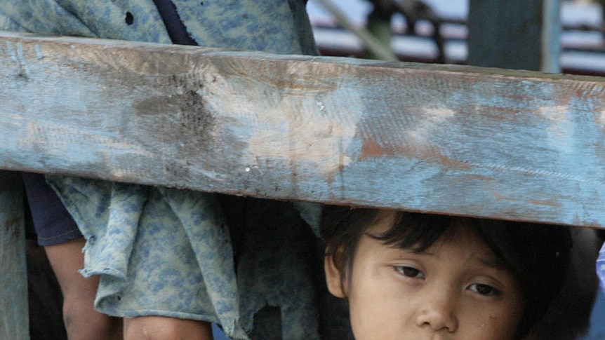 Young asylum seeker girl stares out from a boat