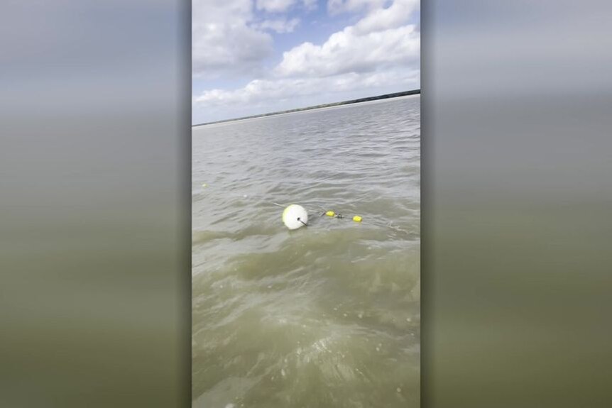 Screengrab from mobile phone vision shows a buoyancy device attached to netting floating on ocean water.