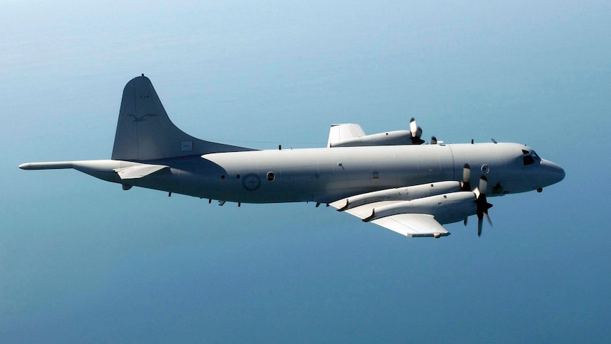 An RAAF AP-3C Orion surveillance aircraft flies over the ocean.