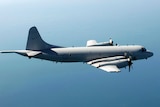 An RAAF AP-3C Orion surveillance aircraft flies over the ocean.