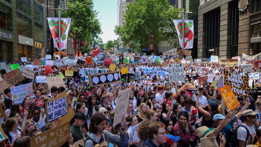 Hundreds of students hold signs at Martin Place protesting for climate change.