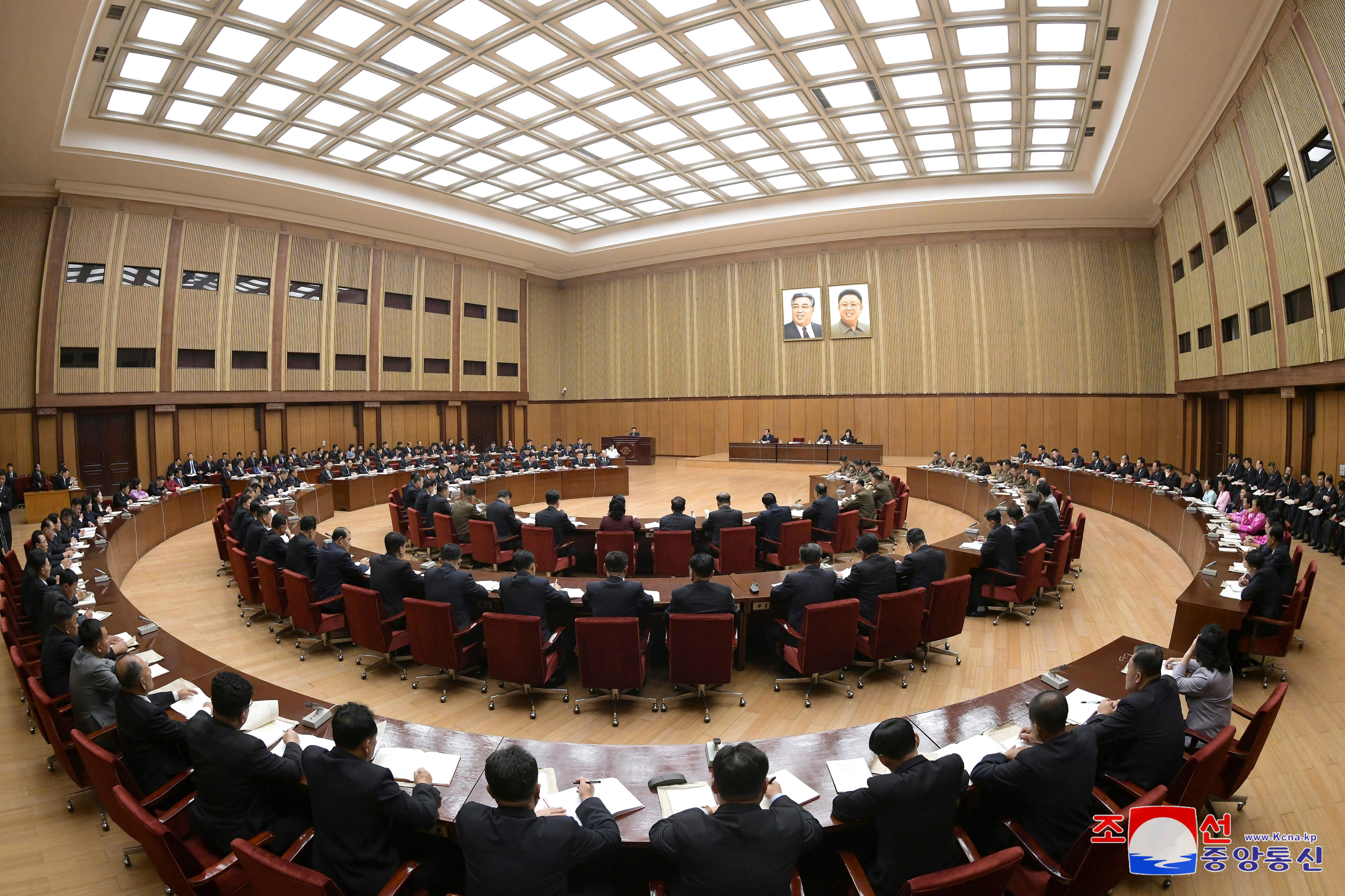 Rings of chairs seated in a hall. 