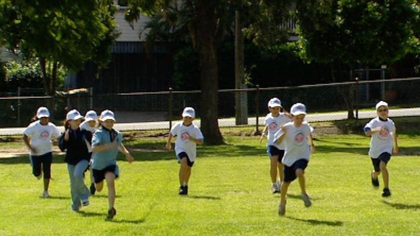 TV still of anonymous primary school children running on school oval at school in Brisbane