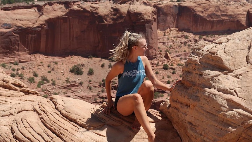 Gabby Petito poses on a cliff