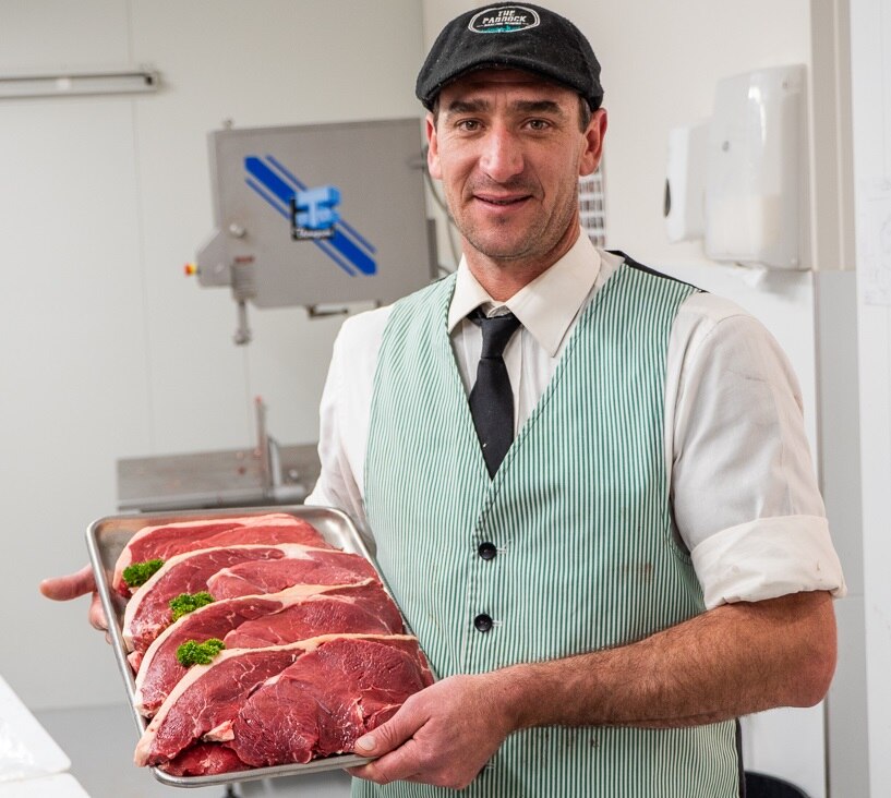 Butcher Jason Patton holds a tray of meat.