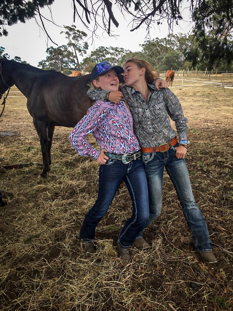 Two young girls wearing western clothes playing. 