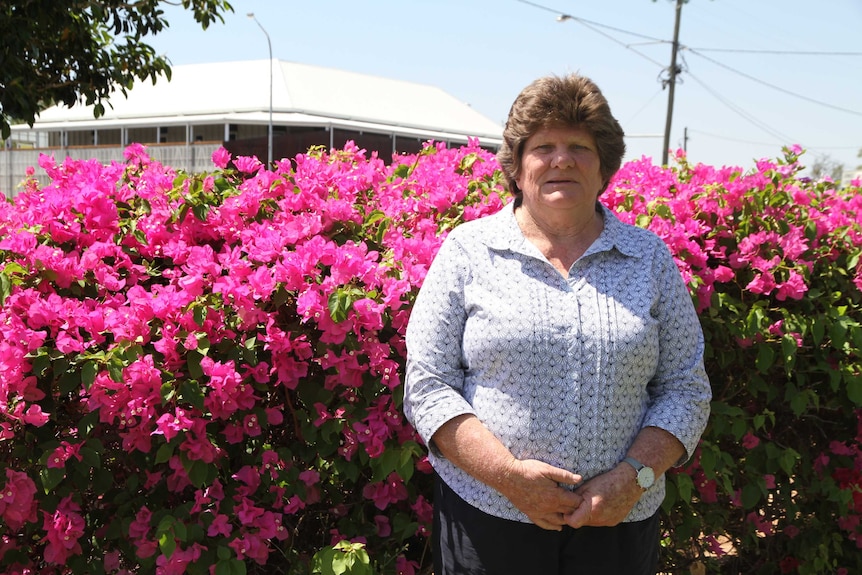 Kaylene Reynolds stands in front of flowers at Bryan Park